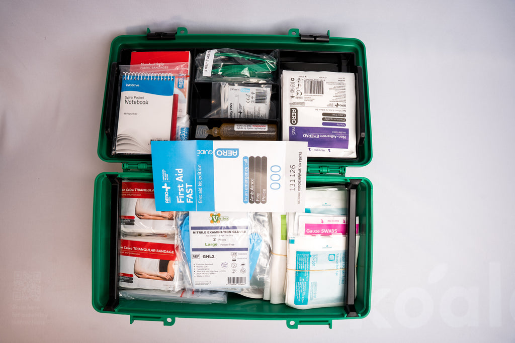 Open first aid kit with medical supplies on a white background