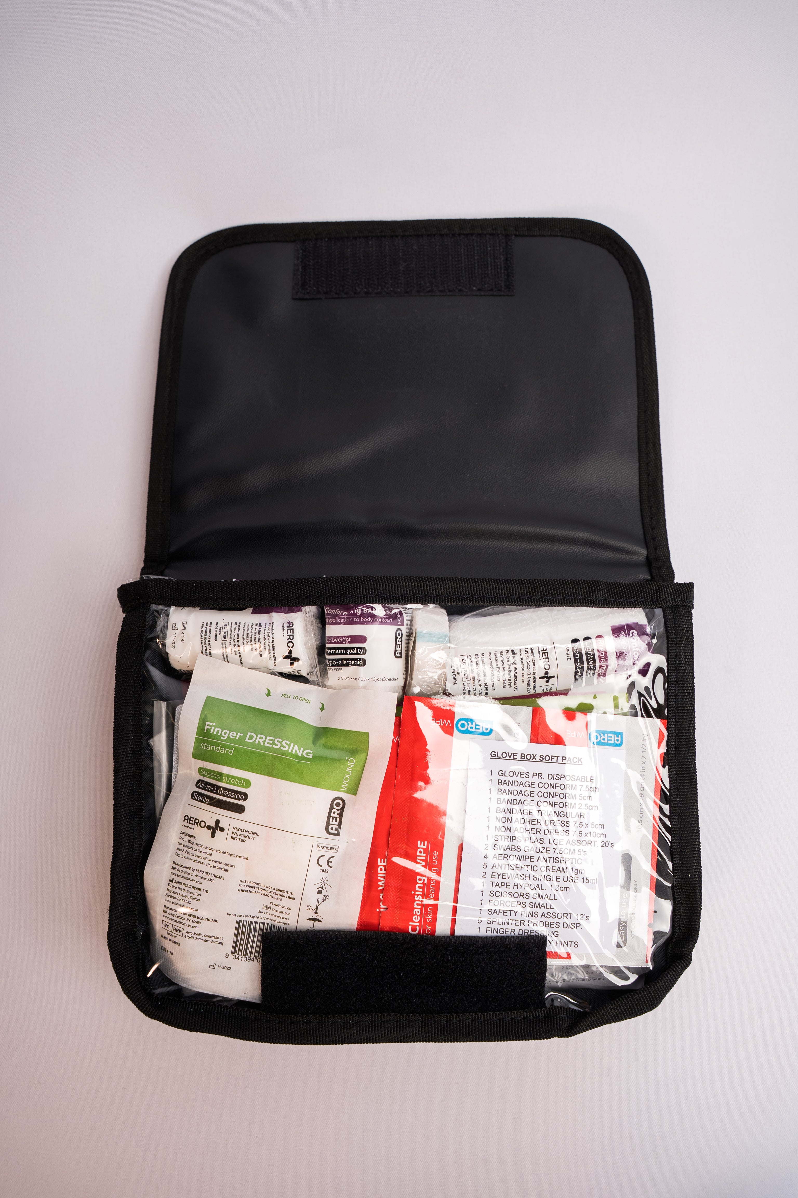 Open first aid kit with medical supplies on a white background