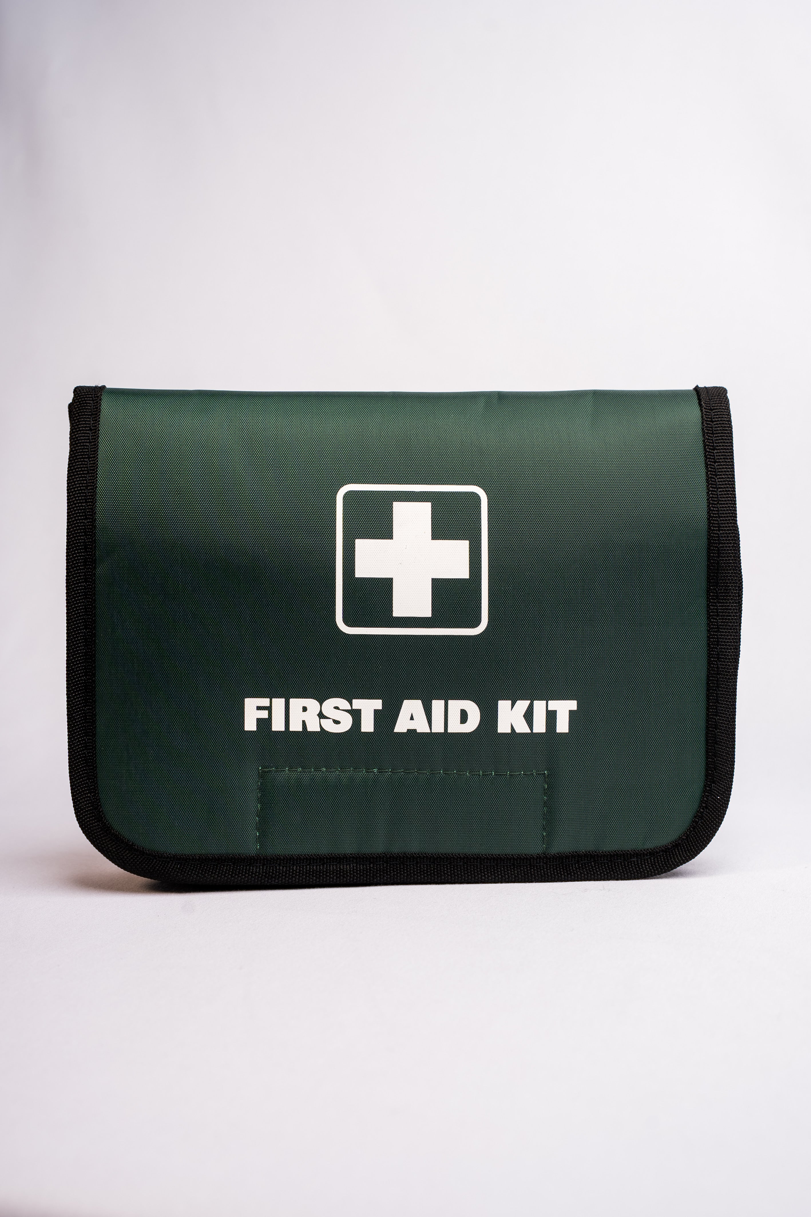 Green first aid kit with a white cross symbol on a white background