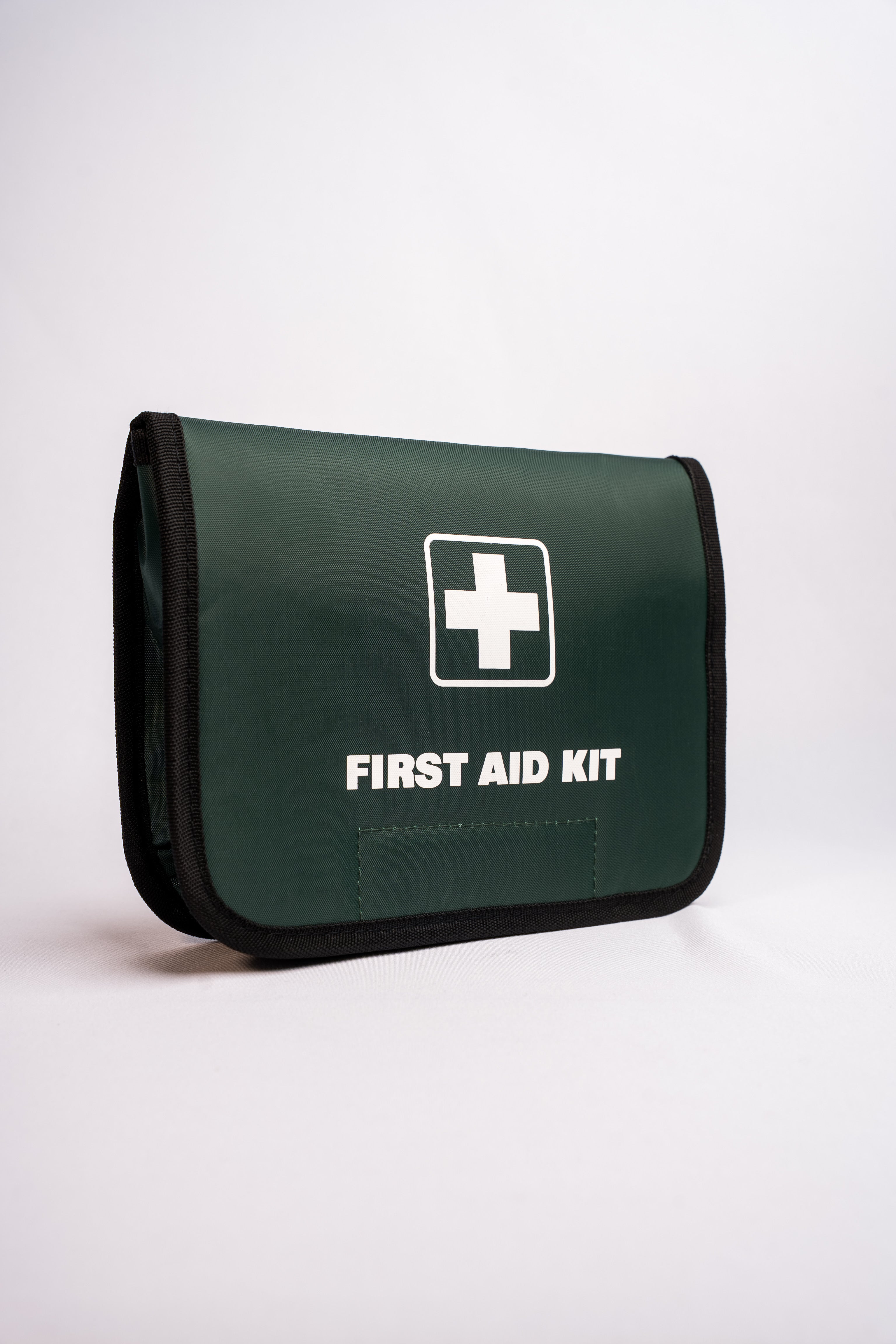 Green first aid kit with a white cross symbol on a white background