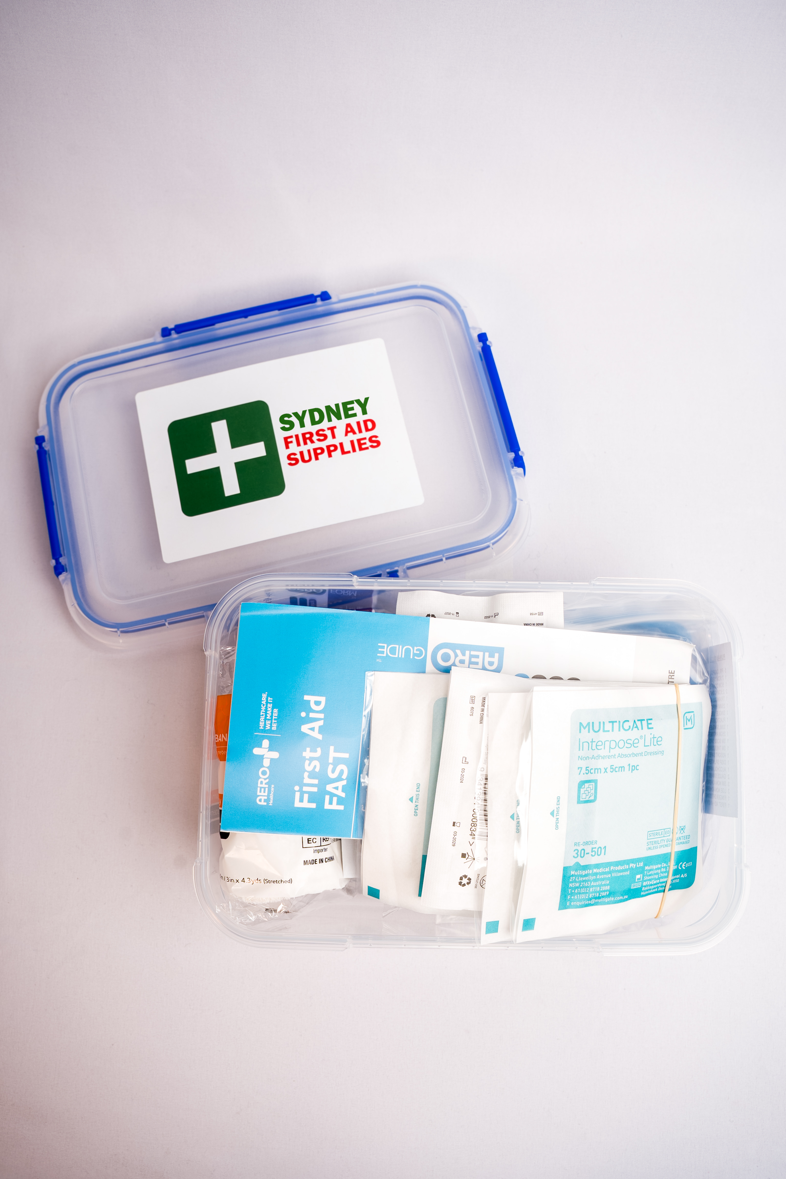 Top down view of an open dustproof, portable first aid kit, showing the included supplies. 