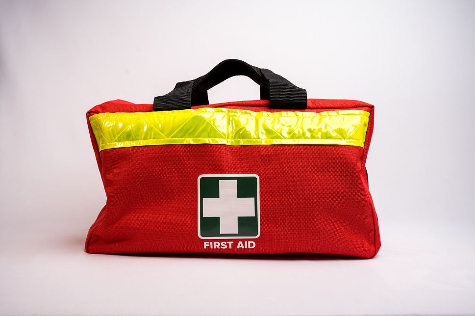 Red first aid kit with a carry handle and high visibility strip on a white background
